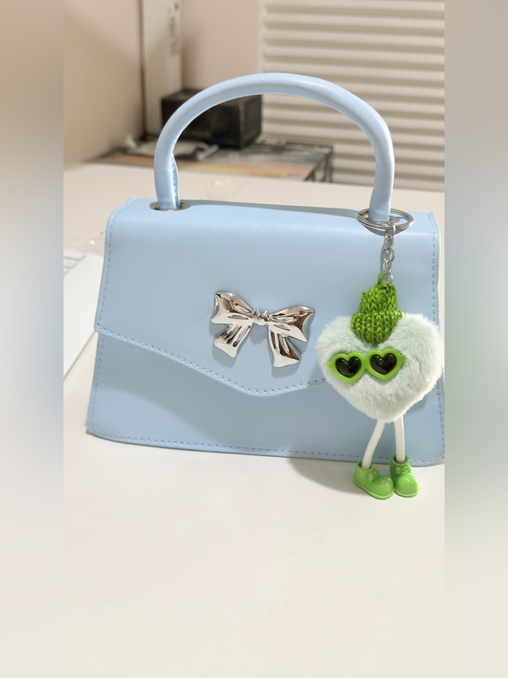 Stylish Light Blue Top-Handle Bag with Silver Bow Accent
